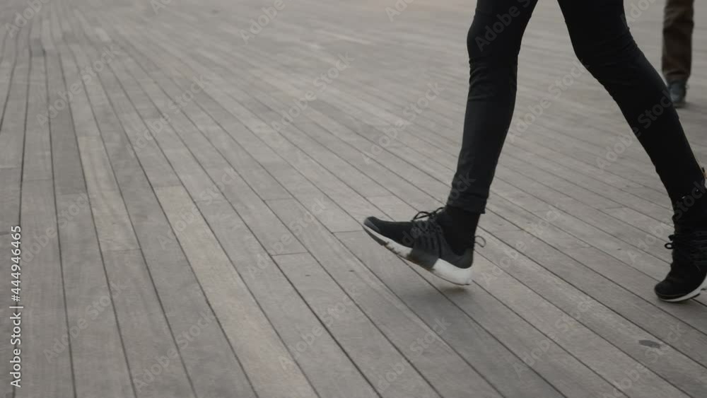Female legs in sport leggings and sneakers running on street Female legs in sport leggings and sneakers running on street
