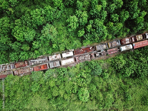 Aerial view of abandoned derelict freight train in forest of trees