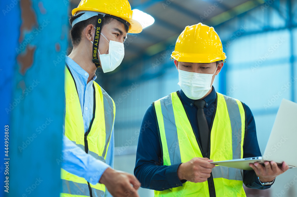 Chief industrial engineer inspects the mask factory. Discuss new projects while using a laptop. They showed an assertive attitude. There are employees wearing protective gear working diligently. Chief industrial engineer inspects the mask factory. Discuss new projects while using a laptop. They showed an assertive attitude. There are employees wearing protective gear working diligently.