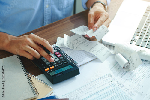 Canvas Print Stressed young man holding pen working on calculator to calculate business data, taxes, bills payment, Start up counting finance