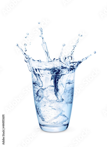 Water splash in glass with ice cubes toned blue isolated on white background.