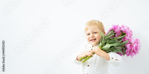 banner. little blonde boy with big bouquet of pink peonies on white background. Love and romantic concept