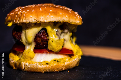 Fresh tasty beef cheeseburger with melted cheese isolated on black backgroundf photo