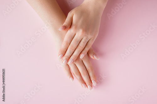 Beautiful female hands on pink background. Spa and body care concept. Image for advertising.