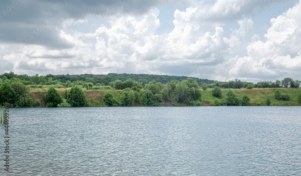 Beautiful landscape, river, forest and clouds on a sunny day.