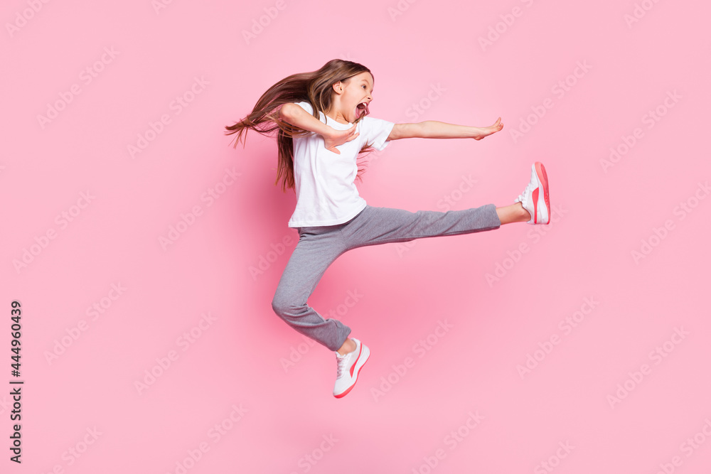 Full size profile photo of nice optimistic blond girl fight wear white t-shirt isolated on pastel pink color background Full size profile photo of nice optimistic blond girl fight wear white t-shirt isolated on pastel pink color background