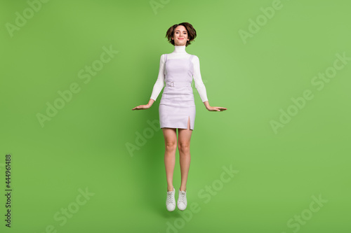 Full length body size photo girl jumping up smiling happy isolated pastel green color background © deagreez