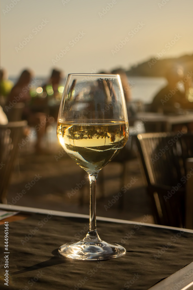 sunset dinner next to the sea with white wine glass sunset dinner next to the sea with white wine glass