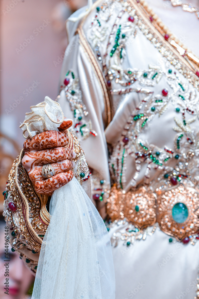 A Moroccan bride close-up wearing a traditional Moroccan caftan with henna on her hands