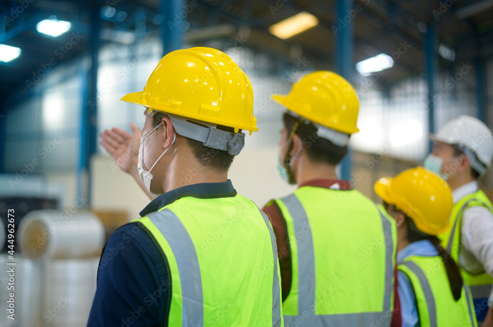 Engineer people are putting a protective helmet on head in warehouse Engineer people are putting a protective helmet on head in warehouse