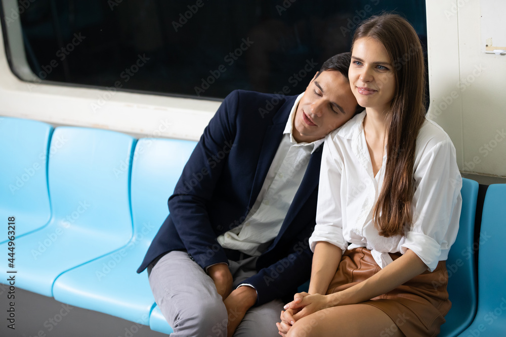 handsome man sleeping on the woman shoulder in the subway train handsome man sleeping on the woman shoulder in the subway train