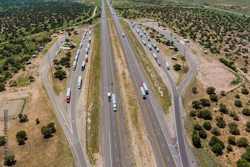 Panoramic aerial horizontal view of rest area truck stop on the car parking endless Interstate highway in desert Arizona