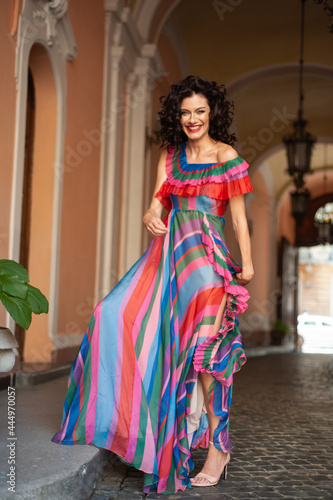 Spectacular sensual beautiful European woman with curled dark hair in a summer dress in the city © alipko