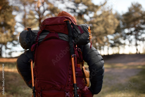 Man climbing on hill for camping trip. Travel all by yourself. Equipment in bag for active tourism, sporty lifestyle. Explore new forest path. Travelling, hiking and adventure time concept