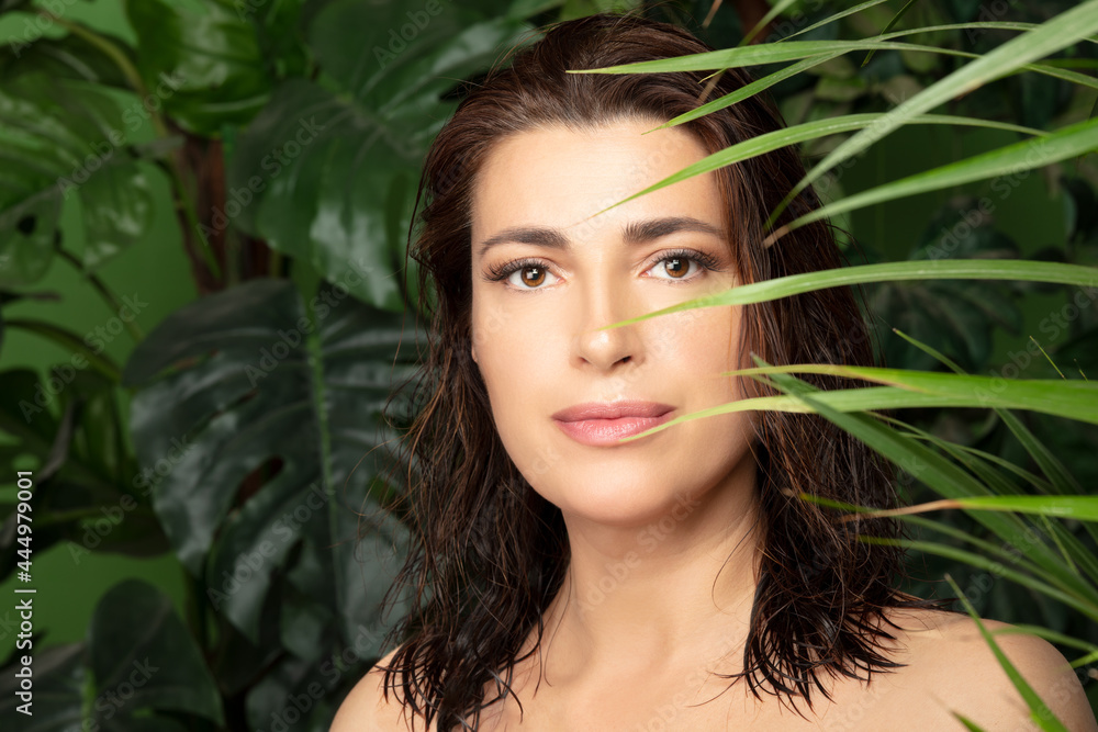 Spa concept of a beautiful woman with healthy fresh skin and healthy hair among tropical fresh green leaves Spa concept of a beautiful woman with healthy fresh skin and healthy hair among tropical fresh green leaves
