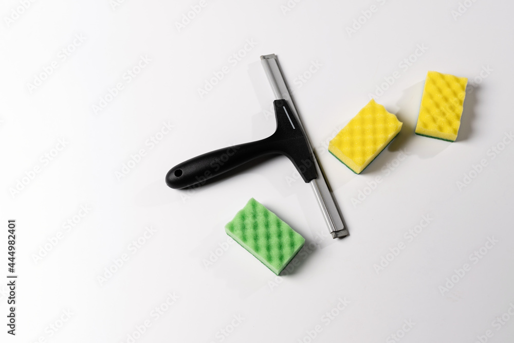 cleaning tools, scraper, window nozzle and colored washcloths on a white background cleaning tools, scraper, window nozzle and colored washcloths on a white background