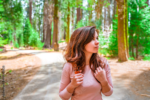 Portrait of a young woman in a picturesque forest in Sequoia National Park, USA