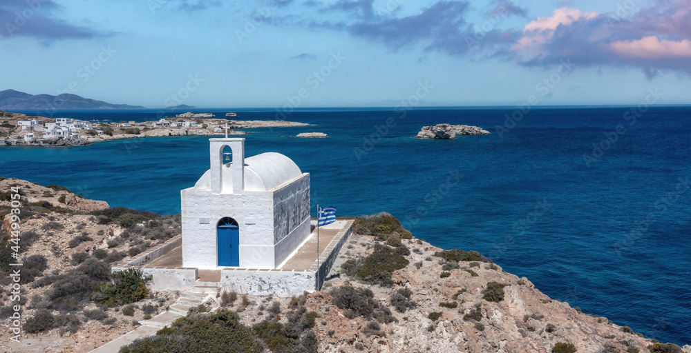 Greece Kimolos island, Cyclades. White small church at Psathi port, aerial drone view.
