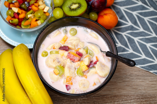 A bowl of yogurt with fruit for dessert. Organic diet yogurt with bananas, kiwi, peaches, plums, apricots