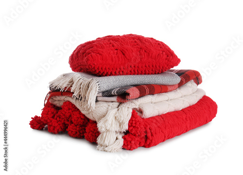 Stack of folded warm plaids with pillow on white background