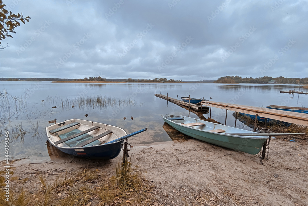 Rowing boat on the shores of Lake Seliger. Walkway on a sandy beach on a cloudy day