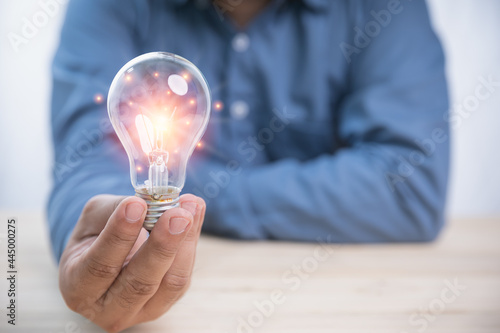 Idea concept inspiration and innovation. Businessman holding a bright light bulb with copy space. Creativity innovation ideas for the future.