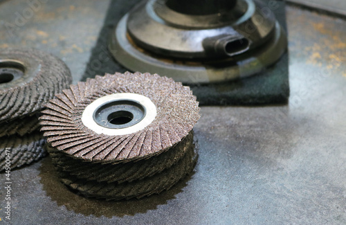 Grinding wheel sand paper flap disc on metal desk.