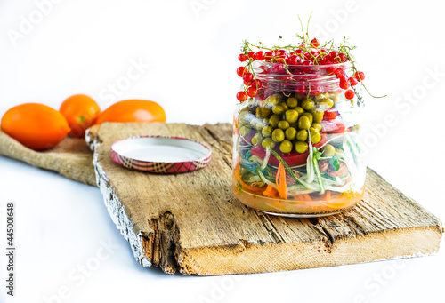 A snack of raw vegetables in a glass. Bright vegetables on a white background
