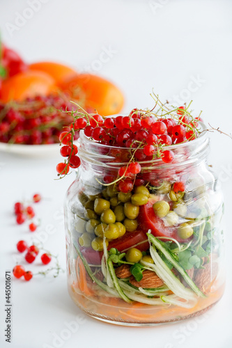 A snack of raw vegetables in a glass. Bright vegetables on a white background