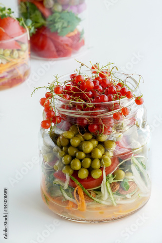 A snack of raw vegetables in a glass. Bright vegetables on a white background