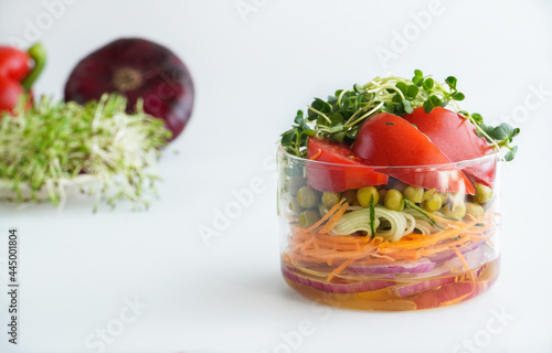 A snack of raw vegetables in a glass. Bright vegetables on a white background
