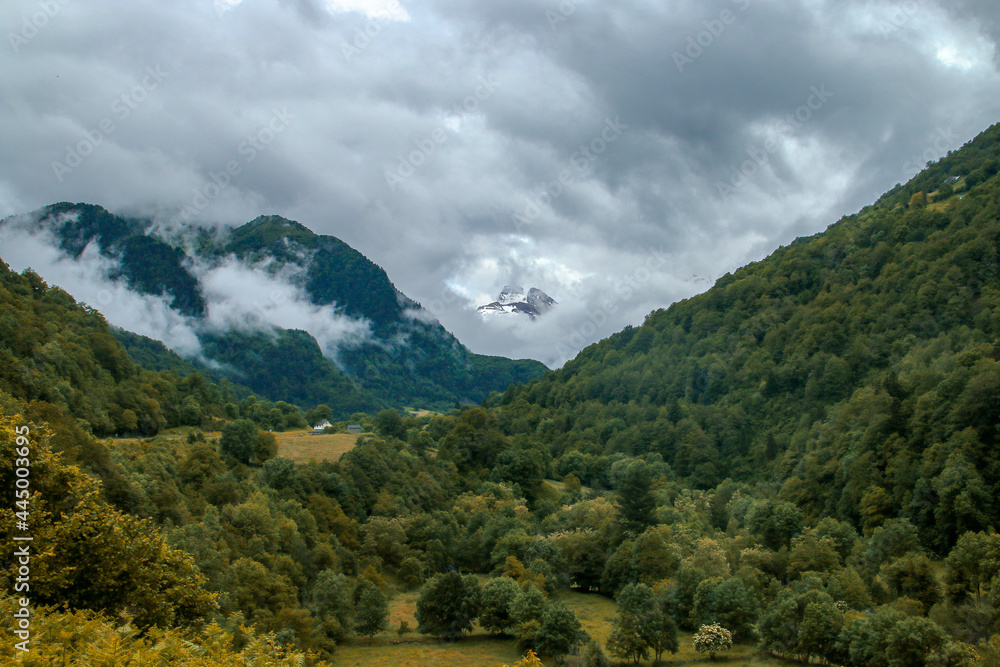 Vista de un paisaje natural en el lado norte de los Pirineos, Borce, Francia. Hermoso valle verde con nubes y montañas brumosas.