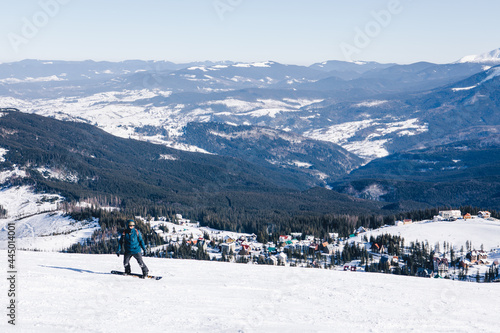 man snowboarder at the top of the slope. beautiful winter mountains. winter vacation