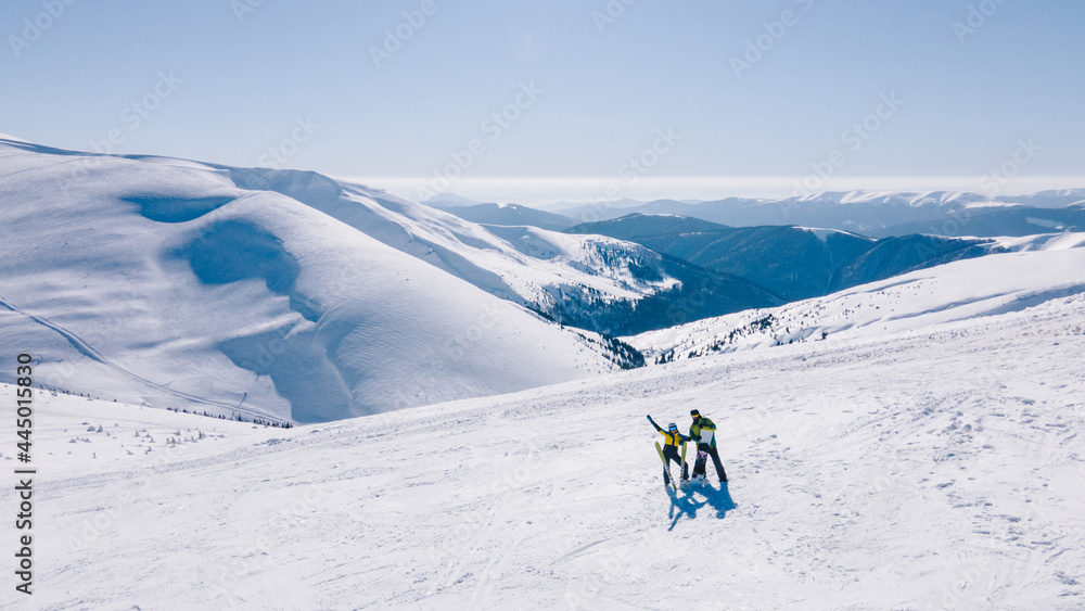 couple skier and snowboarder at the top of the mountains at sunny day