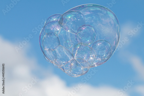 Large Soapy Bubble Floats Against Blue Sky Background © blueiz60