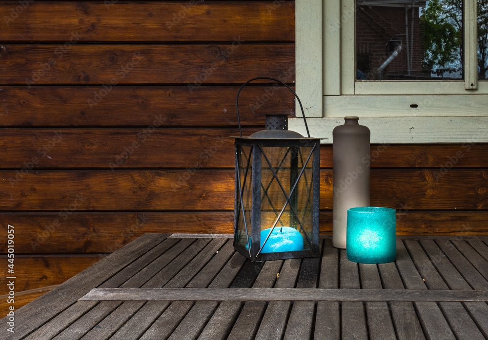 Decorative metal lantern with blue canles glowing on wooden table, vintage stylish design with copy space