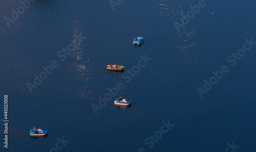 Top view of four boats sailing on a city pond. © gelog67