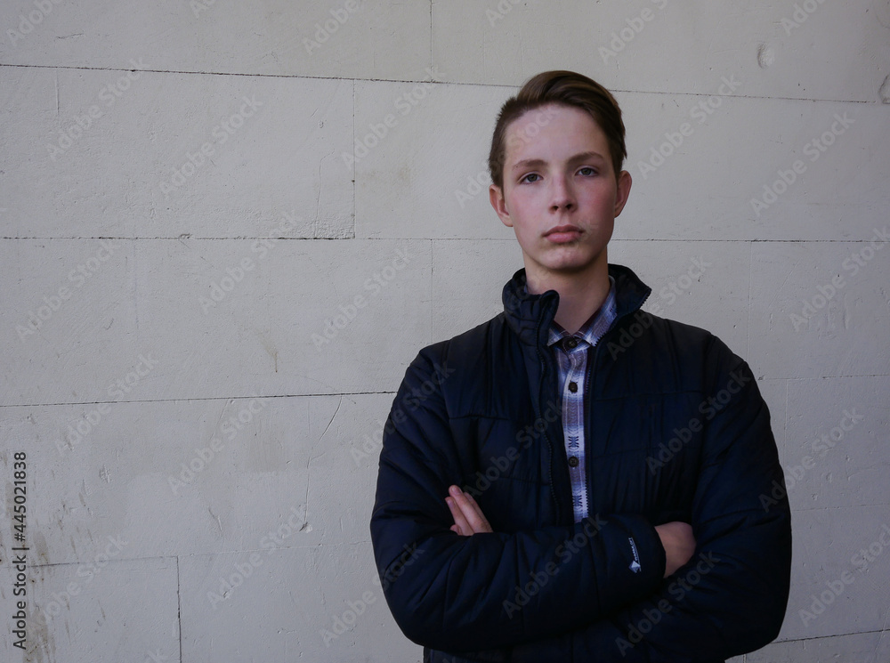 Portrait of a cute boy 13-16 years old in an unbuttoned black jacket.