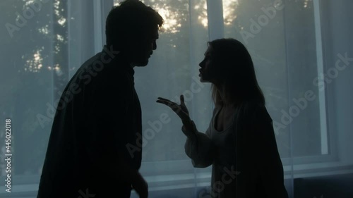 Silhouettes of man and woman shouting at each other, couple quarreling in the evening at home husband and wife screaming. Scandal and crisis in family. Domestic violence, abuse. photo