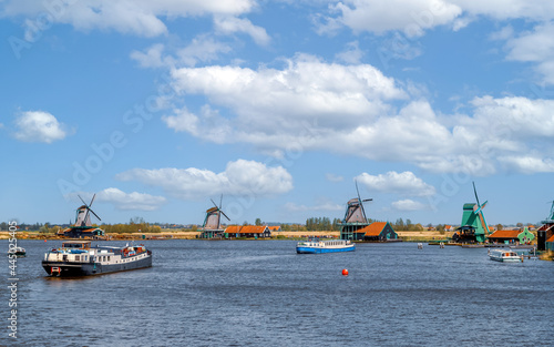 Panoramic view of authentic dutch windmills and ships on the water channel in the historic village of Zaanse Schans, Holland Netherlands.