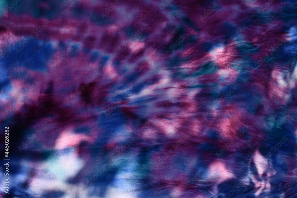 Abstract painted background. Multi-colored pattern in the shibori technique on a thin knitted fabric. Multi-color texture. batik.Textile shibori Abstract painted background. Multi-colored pattern in the shibori technique on a thin knitted fabric. Multi-color texture. batik.Textile shibori