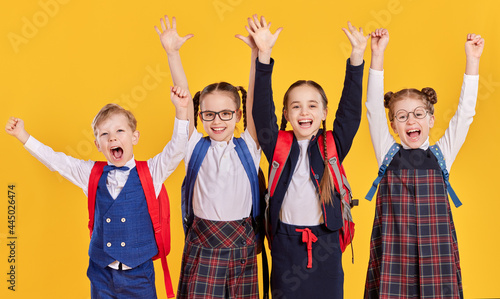 Foto Happy schoolkids with arms raised