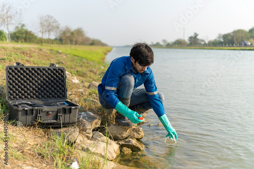 Technician use the Professional Water Testing equipment to measure the water quality at the public canal. Water quality monitoring concept.