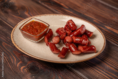 Smoked sausages cut into pieces lie on a plate