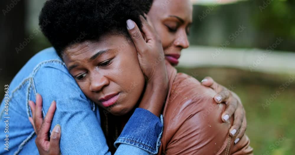 Depressed African woman, friend helping compassionate hug