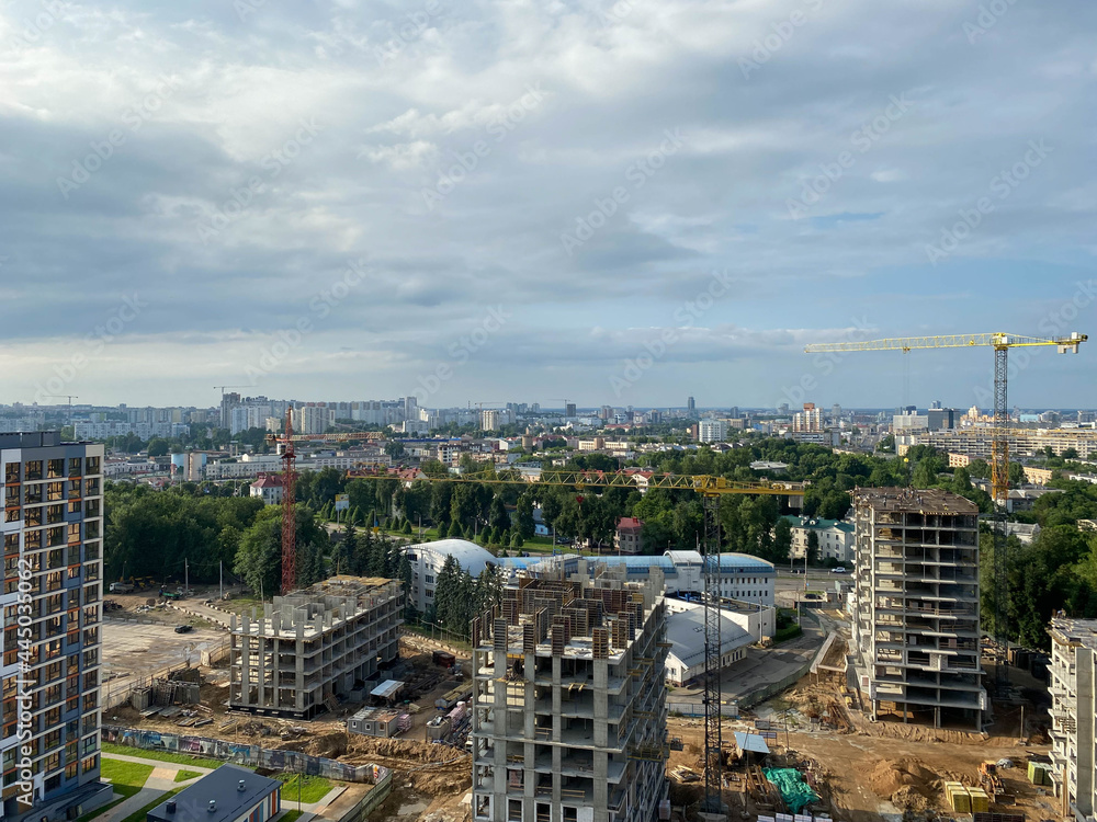 A view from a height of a large modern construction site of tall large houses and multi-storey buildings. A construction site for the development of a new microdistrict in a big city