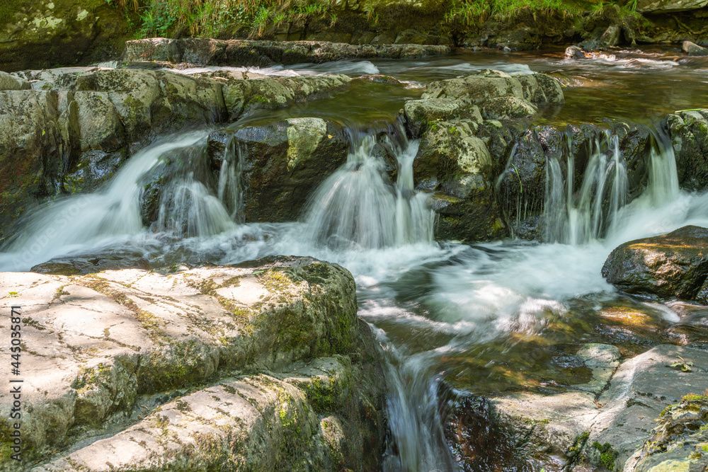 Long exposure of a waterfall on the East Lyn river at Watersmeet In Exmoor National Park Long exposure of a waterfall on the East Lyn river at Watersmeet In Exmoor National Park