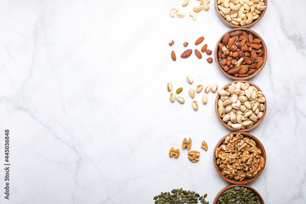 Different kind of nuts in wooden bowls Different kind of nuts in wooden bowls