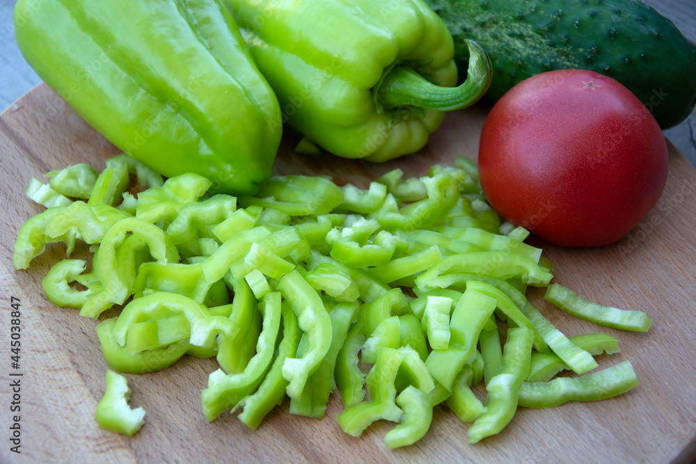 Tomato, cucumber and pepper lie on a wooden background. Harvested a harvest of fresh vegetables from the garden. Tomato, cucumber and pepper lie on a wooden background. Harvested a harvest of fresh vegetables from the garden.