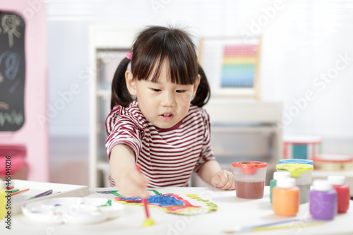 young girl painting hand made craft at home